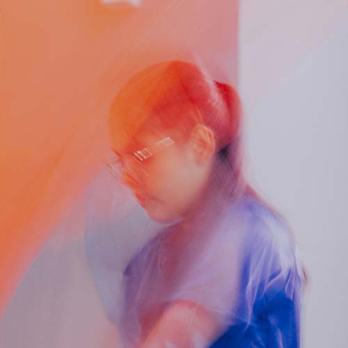 Nurse in blue scrubs seen through warm orange and pink light